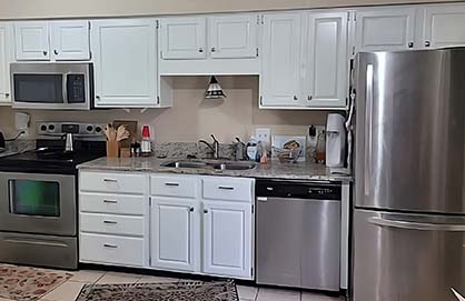 Modern kitchen with stainless steel appliances and microwave.